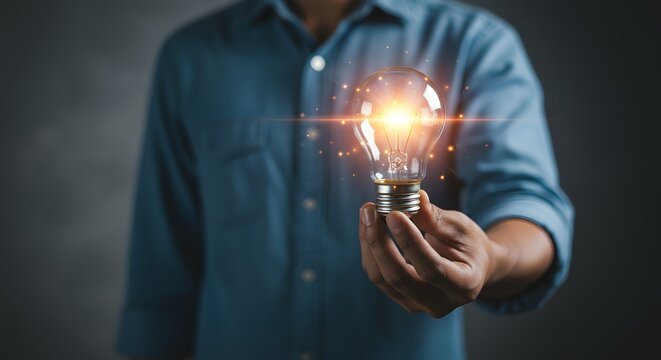Businessman holding glowing light bulb, concept of innovation and creative thinking