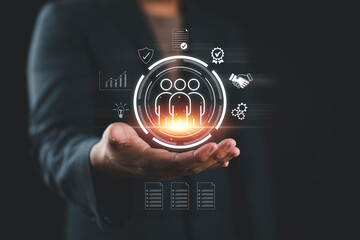Businessman holding digital icons of people and team management, representing human resources, employee data, business leadership, recruitment, and digital HR solutions.