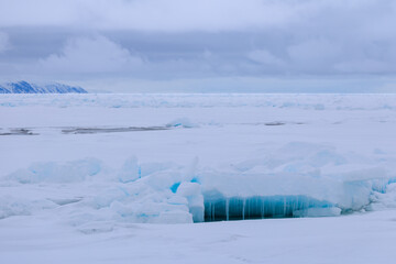 Icicle and blue light reflections in the arctic ice north of Svalbard, Norway © Reto Ammann