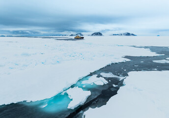 Floating ice on the ocean with mountains in the background in the arctic of Svalbard, Norway © Reto Ammann