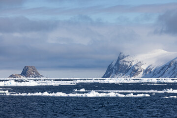 Floating ice on the ocean with mountains in the background in the arctic of Svalbard, Norway © Reto Ammann