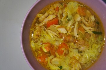 Ayam Soto, or Soto Ayam in Indonesia, is a traditional Indonesian dish featuring chicken, rice vermicelli, peanuts, and turmeric, with the main ingredient being the broth.