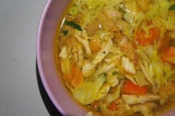 Ayam Soto, or Soto Ayam in Indonesia, is a traditional Indonesian dish featuring chicken, rice vermicelli, peanuts, and turmeric, with the main ingredient being the broth.