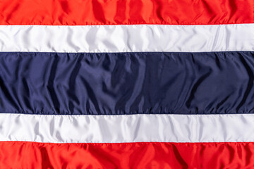 Thai flag in fabric pattern sewn together with a seam. Background Wallpaper of Thailand flag with real wrinkles.