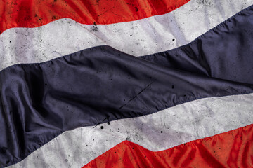 Thai flag in fabric pattern sewn together with a seam. Dark Background Wallpaper wall of Thailand flag waving in wind conveys a sense of ferocity, strength, fighting in battlefield or war.