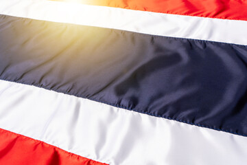 Thai flag in fabric pattern sewn together with a seam. Background Wallpaper of Thailand flag with real wrinkles with the dawn light.