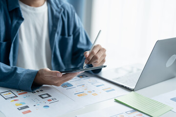 UX UI Designer Planning innovative Mobile App with Paper Wireframe Designs at Workspace.