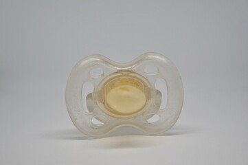 Fototapeta premium Broken baby pacifier with rubber nipple on white background