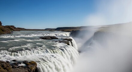 Close-up view of a massive waterfall with emerald green water plunging into a misty abyss, taken in daylight