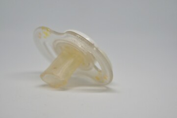 Broken baby pacifier with rubber nipple on white background