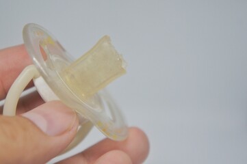 hand holding a broken pacifier