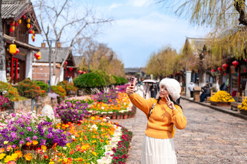 Young female tourist enjoys traveling at Lijiang Ancient Town, The famous tourist destination at Yunnan Province, China
