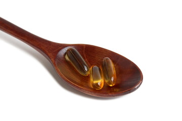 Vitamin D capsules lie on a white background.	