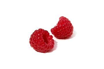 There are two ripe juicy raspberries on a white background.