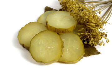 Pieces of pickled cucumber lie on a white background.	