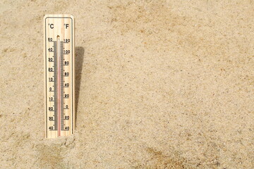 There is a thermometer on the yellow sand showing the heat.