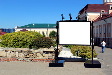An empty advertising banner stands on the park grounds.