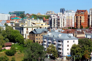 View of a city with houses and trees on a sunny hot summer day.	