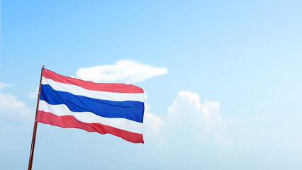 Thailand national flag waving in the sky with a blue sky background. Concept of Thailand Independence Day
