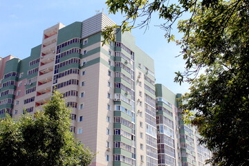 Background of the facade of a house with large windows and trees in summer.