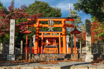 Kyoto, Japan - November 22, 2024 : The entrance and vermilion torii gate of Yamakage Jinja Shrine, dedicated to the god of cooking, surrounded by autumn foliage.