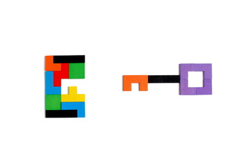 A key made of brightly colored puzzle pieces is laid out on a white background.
