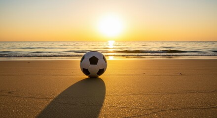 Silhouetted sunset beach soccer concept. A soccer ball rests on the beach as the sun sets over the horizon, creating a serene atmosphere.