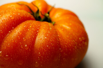 Close-up of a ripe, juicy red tomato glistening with fresh water droplets, showcasing its vibrant color and texture