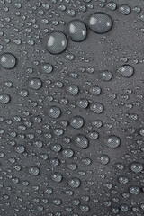 Water drops on the dark gray fabric, vertical