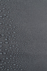 Water drops on the dark gray fabric, vertical