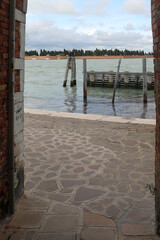 Adriatic Sea and the Cemetery Of Venice Island between two wall of buildings and the street called FONDAMENTA NUOVE in Northern Italy