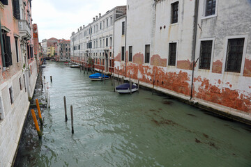wide navigable canal in Venice Island in Northern Italy with moored boats