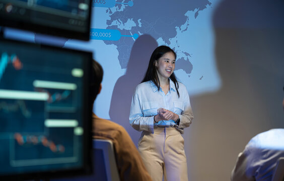 Businesswoman presents a marketing strategy using a ship route map, promoting global product distribution and sales logistics in a corporate setting during a professional presentation.
