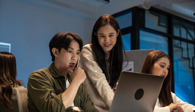 Young Asian business people working late into the night in the office, meeting, brainstorming, presentation working about coding