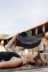 Young woman relaxing with sun hat by the poolside