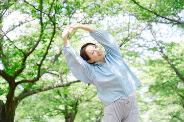 屋外で準備運動をする40代女性