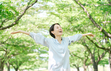 屋外で深呼吸する40代女性