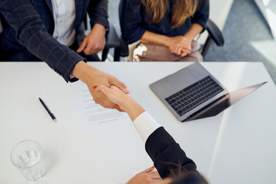 Recruiter shaking hand with candidate after successful interview at office