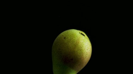 Green pear falling into water in slow motion on a sleek black background - Powered by Adobe