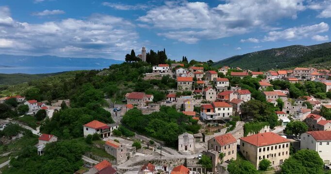 Aerial: top of the hill of Hvar during the day with fortress and Adriatic Sea in the back in Croatia, orbit drone shot