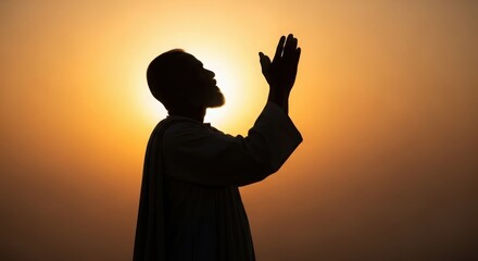 Man s silhouette reaching upwards towards a bright warm sunset sky in prayer or supplication silhouette