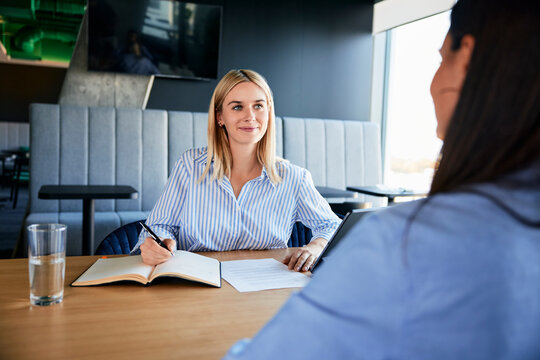 Smiling recruiter taking interview of candidate at desk