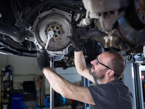 Mechanic repairing car wheel in auto repair shop