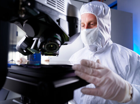 Engineer checking silicon wafer chip using semiconductor in laboratory
