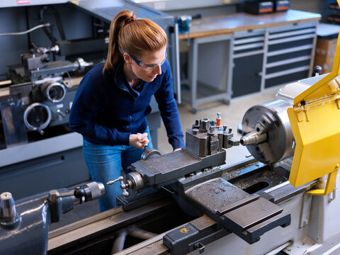 Metalworking engineer operating lathe machine in industry