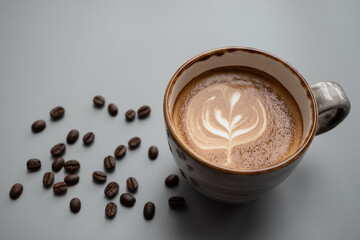 Rosetta Latte art in a ceramic cup  place on gray background  with copy space left, there are coffee beans around