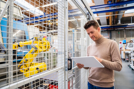 Mature businessman using tablet PC in industry