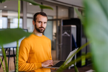 Young businessman with laptop in office