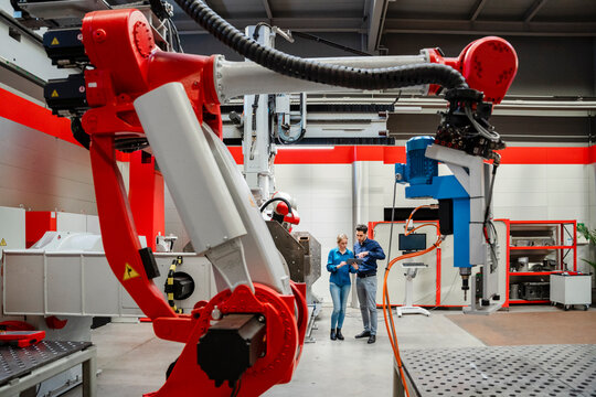 Colleagues working together in robot factory