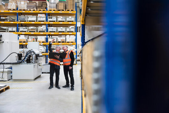 Engineers standing with file folder and planning in factory